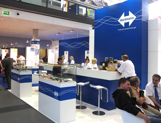 Blau-weißer Messestand der Marke Hartmann mit Theke und Produktvitrinen
