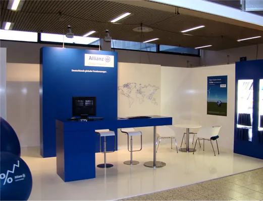 Blauer Allianz Messestand mit Stehtischen und Weltkarten-Grafik