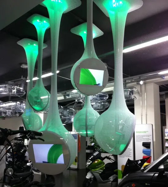 Skulpturale, grün beleuchtete Display-Objekte einer Eventinstallation